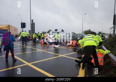 Colnbrook, Royaume-Uni. 27 septembre 2021. Les activistes du climat isolent la Grande-Bretagne d’une route de la M25 à la sortie 14 près de l’aéroport d’Heathrow dans le cadre d’une campagne visant à pousser le gouvernement britannique à apporter des changements législatifs significatifs pour commencer à réduire les émissions. Les activistes exigent que le gouvernement promette immédiatement à la fois de financer et d’assurer l’isolation de tous les logements sociaux en Grande-Bretagne d’ici 2025, et de produire dans les quatre mois un plan national juridiquement contraignant visant à financer et à assurer la rénovation complète des maisons entières à faible consommation d’énergie et à faible émission de carbone, sans coûts externalisés, Banque D'Images