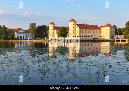 Château de Rheinsberg se reflétant dans l'eau à Ostprignitz-Ruppin, Noth-est de l'Allemagne, les blocs d'illy et l'herbe de mer est au premier plan Banque D'Images