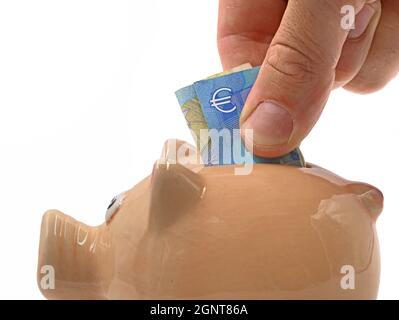 gros plan de la main masculine mettant euro billet dans la banque de porc, économie d'argent concept image isolée sur fond blanc Banque D'Images