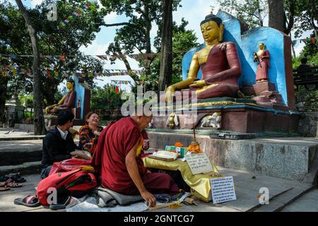 Katmandou, Népal - septembre 2021: Les gens faisant une offrande devant une statue de Bouddha à la Swayambhunath Stupa le 25 septembre 2021 à Katmandou Banque D'Images