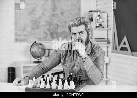 Concept de stratégie. Professeur d'école. Faites votre propre pensée de manière indépendante. Leçon d'échecs. Jeu de société. Homme intelligent jouant aux échecs. Figures sur le plateau d'échecs Banque D'Images
