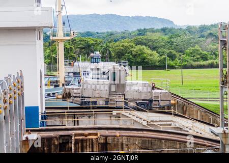 Locomotives électriques, connues sous le nom de mules, guidant un navire à conteneurs à travers les écluses de Gatun, partie du canal de Panama. Banque D'Images