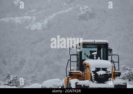 Chasse-neige dégageant une route de montagne pendant une tempête hivernale violente Banque D'Images