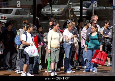 Les acheteurs et les piétons attendent de traverser une rue à Auckland, en Nouvelle-Zélande, pendant la saison de shopping de décembre. Banque D'Images