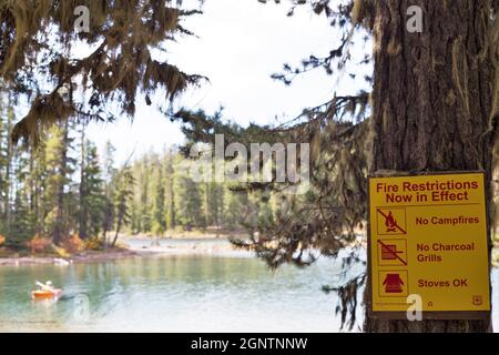 Un signe d'avertissement de restrictions d'incendie sur un arbre à côté du lac Waldo près d'Oakridge, Oregon, dans les montagnes Cascade. Banque D'Images