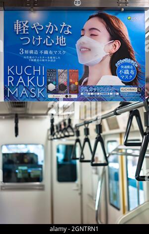 tokyo, japon - août 30 2021 : gros plan sur une affiche publicitaire japonaise dans un train représentant une femme souriante portant un visage à la mode Banque D'Images