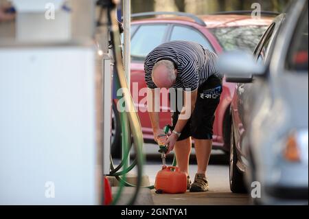 Un homme remplit un conteneur d'essence dans une station-service Newport Tesco Extra alors que l'achat de panique de carburant continue. Banque D'Images