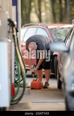 Un homme remplit un conteneur d'essence dans une station-service Newport Tesco Extra alors que l'achat de panique de carburant continue. Banque D'Images