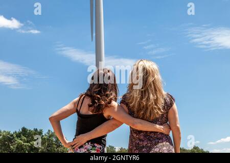 deux belles femmes voyageurs tout en prenant des photos avec une éolienne en arrière-plan. concept de destination touristique Banque D'Images