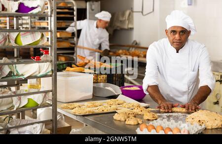 Boulanger masculin travaillant avec des baguettes formant de la pâte Banque D'Images