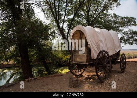 Wagon couvert sur une colline près d'une source naturelle.Le wagon est prêt à être attelé et à traverser la prairie. Banque D'Images