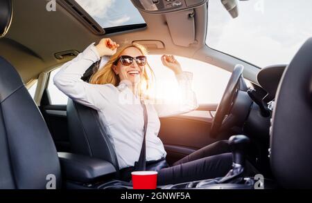 Femme positive conduisant la voiture Banque D'Images