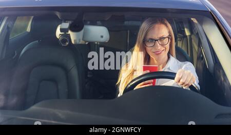 Femme buvant du café en voiture Banque D'Images