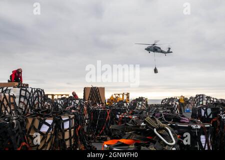 210925-N-OJ308-1558 MER MÉDITERRANÉE (SEPT 25, 2021) un hélicoptère MH-60S Sea Hawk, attaché aux « Chargers » de l'Escadron de combat de la mer (HSC) 26, dépose des cargaisons sur le pont de vol du navire d'assaut amphibie de classe Wasp USS Iwo Jima (LHD 7) lors d'un réapprovisionnement en mer, le 25 septembre 2021. Iwo Jima est en cours en mer Méditerranée avec le 4ième Escadron amphibie et le 24e corps expéditionnaire maritime (UMM) dans le cadre du Groupe de prêt amphibie Iwo Jima. (É.-U. Photo de la marine par le Matelot de 1re classe Isaac A. Rodriguez) Banque D'Images