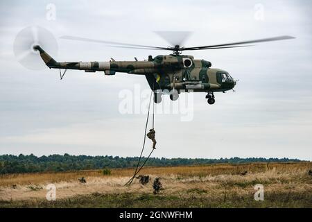 Un parachutiste de l'armée américaine affecté au 1er Bataillon, 503e Régiment d'infanterie de parachutisme coordonne l'établissement d'une posture de sécurité commune sur une zone de chute avec un parachutiste de la Brigade lituanienne - polonaise - ukrainienne après avoir mené une opération aéroportée conjointe. Cette formation s'inscrit dans le cadre de l'exercice Rapid Trident 21 au Centre international de sécurité pour le maintien de la paix près de Yavoriv, en Ukraine, le 25 septembre 2021. Rapid Trident 21 compte environ 6,200 membres du personnel de 12 nations, du 20 septembre au 1er octobre 2021, au Centre international de sécurité pour le maintien de la paix près de Yavoriv, en Ukraine. Trident rapide Banque D'Images