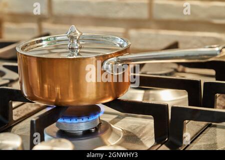 Casserole de cuivre sur feu doux sur le poêle pour faire la sauce Banque D'Images