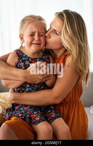 Mère réconfortant sa petite fille qui pleure. Parentalité, concept de soutien familial Banque D'Images