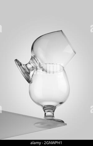 deux verres de cognac en verre transparent l'un sur l'autre isolés sur fond blanc. Pyramide des produits d'épicerie. Arrière-plan blanc Banque D'Images