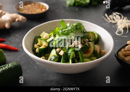 Salade de concombres chinois épicés avec coriandre, gingembre, piment, vinaigre noir sur la cuisine asiatique. Concombres épicés. Vue de dessus. Co. Populaire Banque D'Images