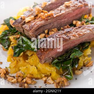 accompagner le steak de plantain écrasé, les verts de collard et les arachides de gingembre, gros plan Banque D'Images