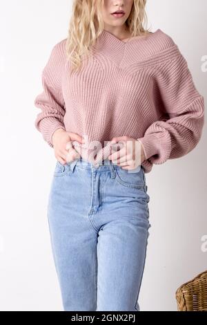 Photo d'une adolescente posant dans un Jean bleu à taille haute et un chandail. Détails des vêtements pour femmes Banque D'Images