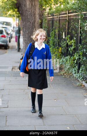 Année 7 fille / écolière étudiante / élève / enfant / enfant en uniforme neuf arrivant le premier jour de l'école secondaire. Terme d'automne. ROYAUME-UNI (127) Banque D'Images