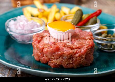 steak tartare avec œuf ouvert sur bois Banque D'Images