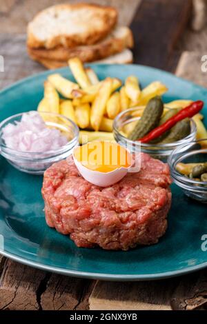 steak tartare avec œuf ouvert sur bois Banque D'Images