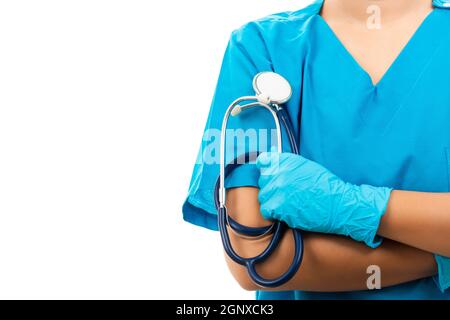 Une infirmière féminine avec stéthoscope met des gants en caoutchouc et porte un masque médical, une femme médecin en uniforme bleu bras croisés, tir en studio isolé Banque D'Images