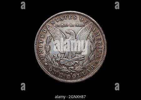 USA One Dollar Morgan Silver coin réplique datée de 1880 avec une image d'un aigle écartée sur le dos découpé et isolé sur un fond noir, stock Banque D'Images