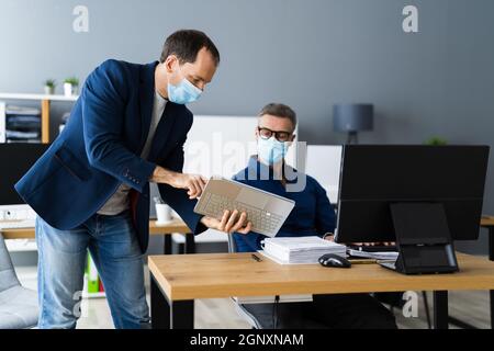 Formation de l'assistant employé portant un masque facial au bureau Banque D'Images
