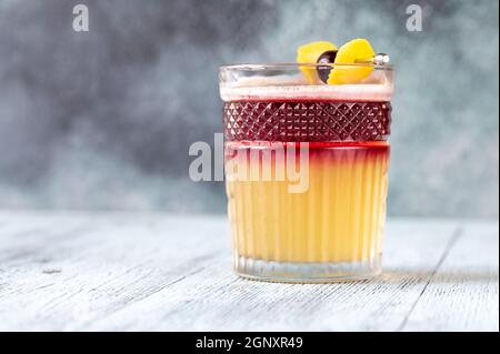 Verre de New York Sour garni de cerise cocktail et zeste de citron Banque D'Images