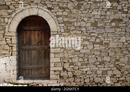 Mur en pierre avec ancienne porte en bois dans la vieille ville de Berat, Albanie Banque D'Images