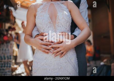 Marié embrassant la mariée de son dos portant des anneaux à Mostar, Bosnie-Herzégovine Banque D'Images
