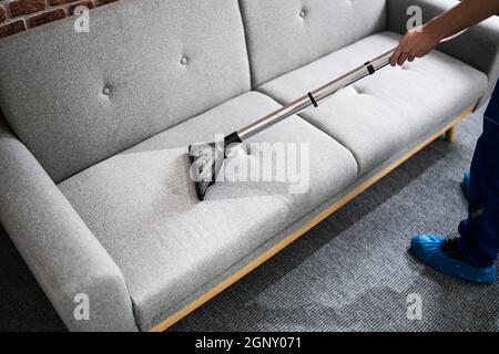 Service professionnel de nettoyage de canapé en utilisant l'aspirateur Banque D'Images