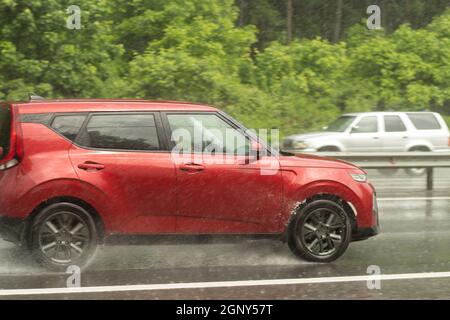 La voiture roule sur une route humide. Route glissante après la pluie. Éclaboussures sous les roues de transport. Pluie sur l'autoroute. L'été en baisse dans les s. Banque D'Images