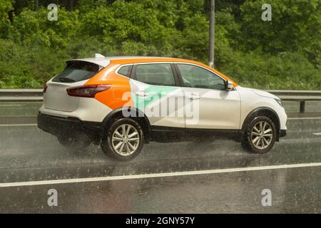 La voiture roule sur une route humide. Route glissante après la pluie. Éclaboussures sous les roues de transport. Pluie sur l'autoroute. L'été en baisse dans les s. Banque D'Images