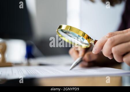 Auditeur effectuant une enquête de fraude fiscale à l'aide de la loupe Banque D'Images