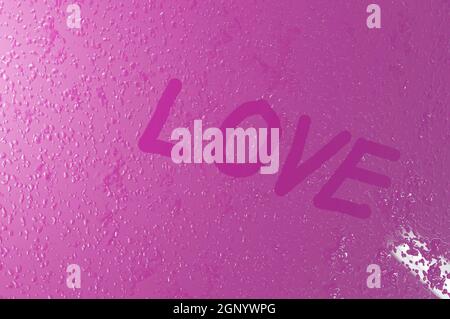 Image 3D , écrit '' l'amour 'sur la vitre de fenêtre avec des gouttes sur fond rose. Concept Saint Valentin, mariage Banque D'Images
