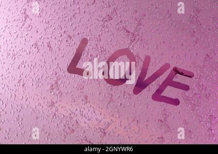Image 3D , écrit '' l'amour 'sur la vitre de fenêtre avec des gouttes sur fond rose. Concept Saint Valentin, mariage Banque D'Images
