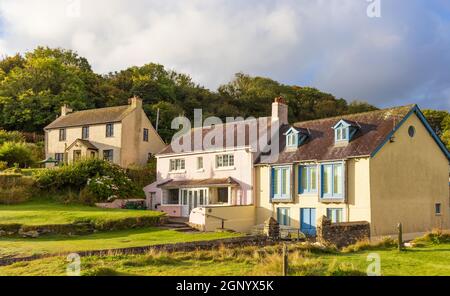 Attrayant cottage gallois battant pavillon gallois surplombant les vestiges de l'église Saint-Brynach. MCG-YR-Eglwys, Dinas, Pembrokeshire, pays de Galles. ROYAUME-UNI. Banque D'Images