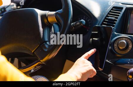 Femme asiatique à l'intérieur d'une voiture et utilisant l'écran tactile activé écran vide du smartphone mobile pendant la conduite de la voiture dans le matin sur l'autoroute, elle trouve la navigation Banque D'Images