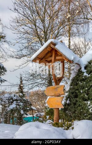 magnifique panneau en bois dans le jardin d'hiver recouvert de neige fraîche Banque D'Images