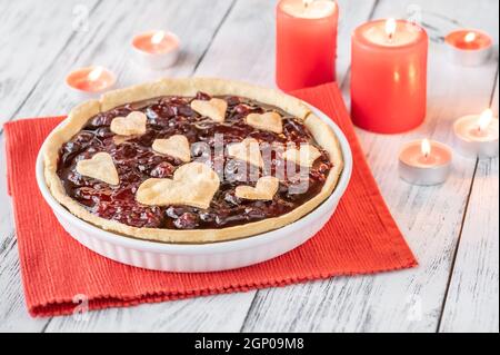 Tarte à la confiture de cerises de Saint-Valentin avec bougies allumées Banque D'Images