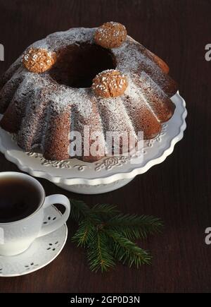 Gâteau au chocolat avec sucre glace et tasse de café. Arrière-plan de Noël . Banque D'Images