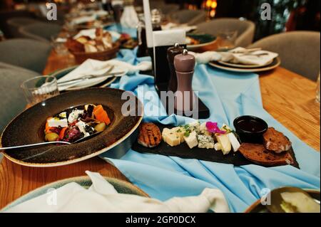 Tables joliment agentées avec nourriture, verres et appareils électroménagers au restaurant. Banque D'Images