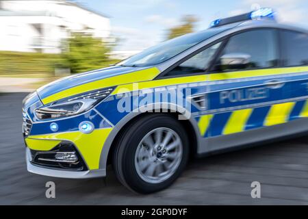 ILLUSTRATION - 28 septembre 2021, Rhénanie-du-Nord-Westphalie, Gütersloh : une voiture de police conduit avec ses feux bleus allumés. (Prise de vue avec effet de zoom) photo : David Inderlied/dpa Banque D'Images