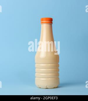 bouteille en plastique beige pour lait sur fond bleu, contenant pour produits liquides Banque D'Images