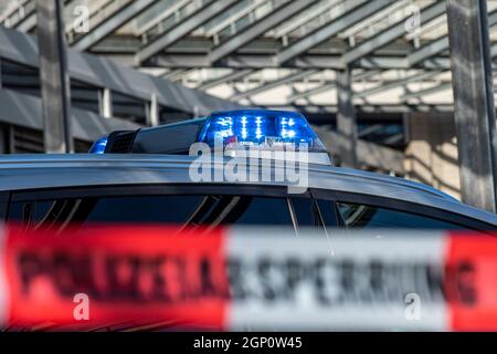 ILLUSTRATION - 28 septembre 2021, Rhénanie-du-Nord-Westphalie, Gütersloh : une bande protectrice avec l'inscription « barrière de police » est étirée devant une voiture de police. Photo: David Inderlied/dpa Banque D'Images