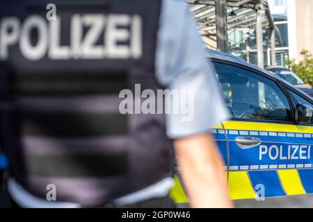 ILLUSTRATION - 28 septembre 2021, Rhénanie-du-Nord-Westphalie, Gütersloh : un policier est debout devant une voiture de patrouille. Photo: David Inderlied/dpa Banque D'Images